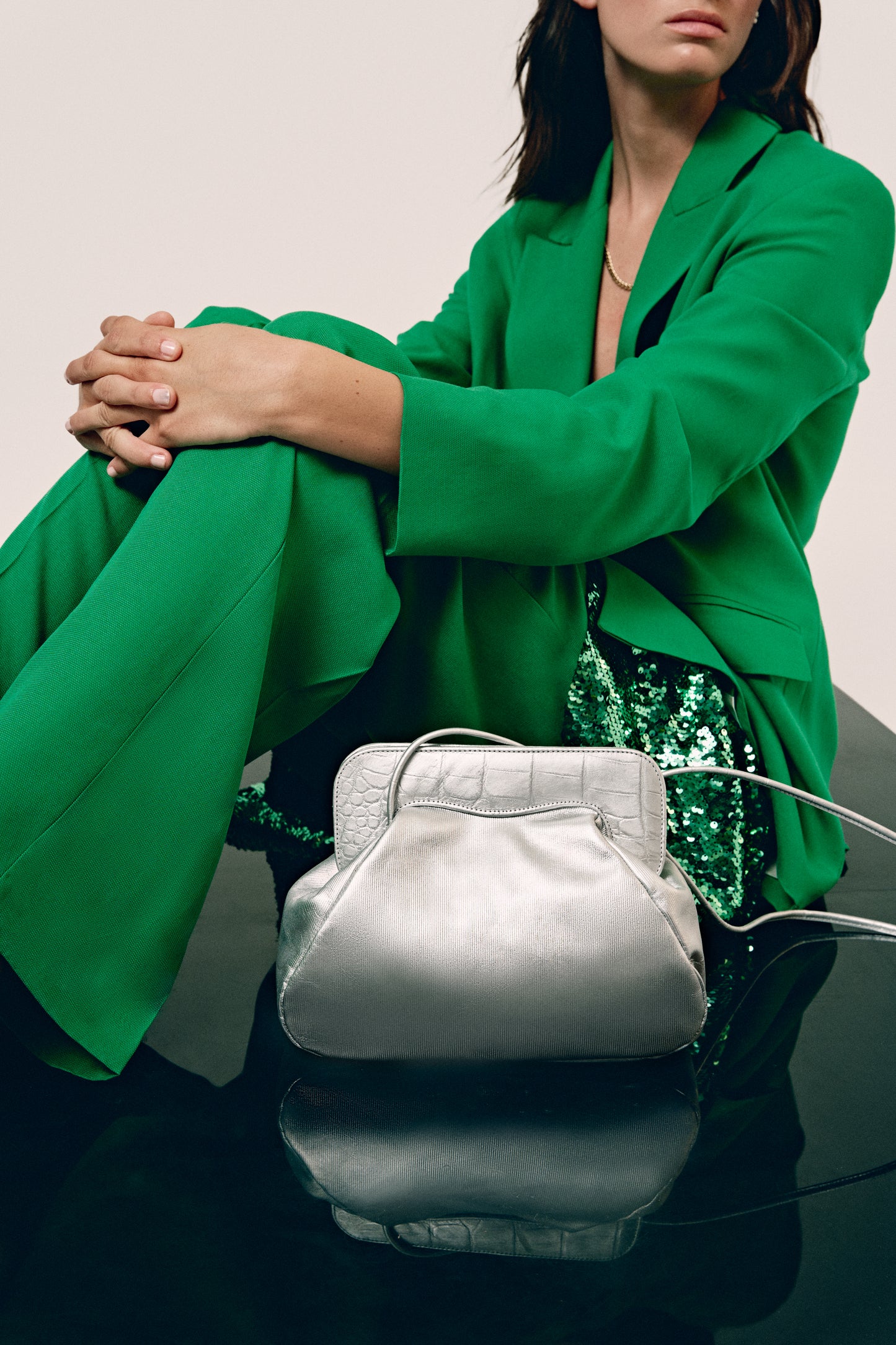 Chica de verde con bolso plateado de hombro
