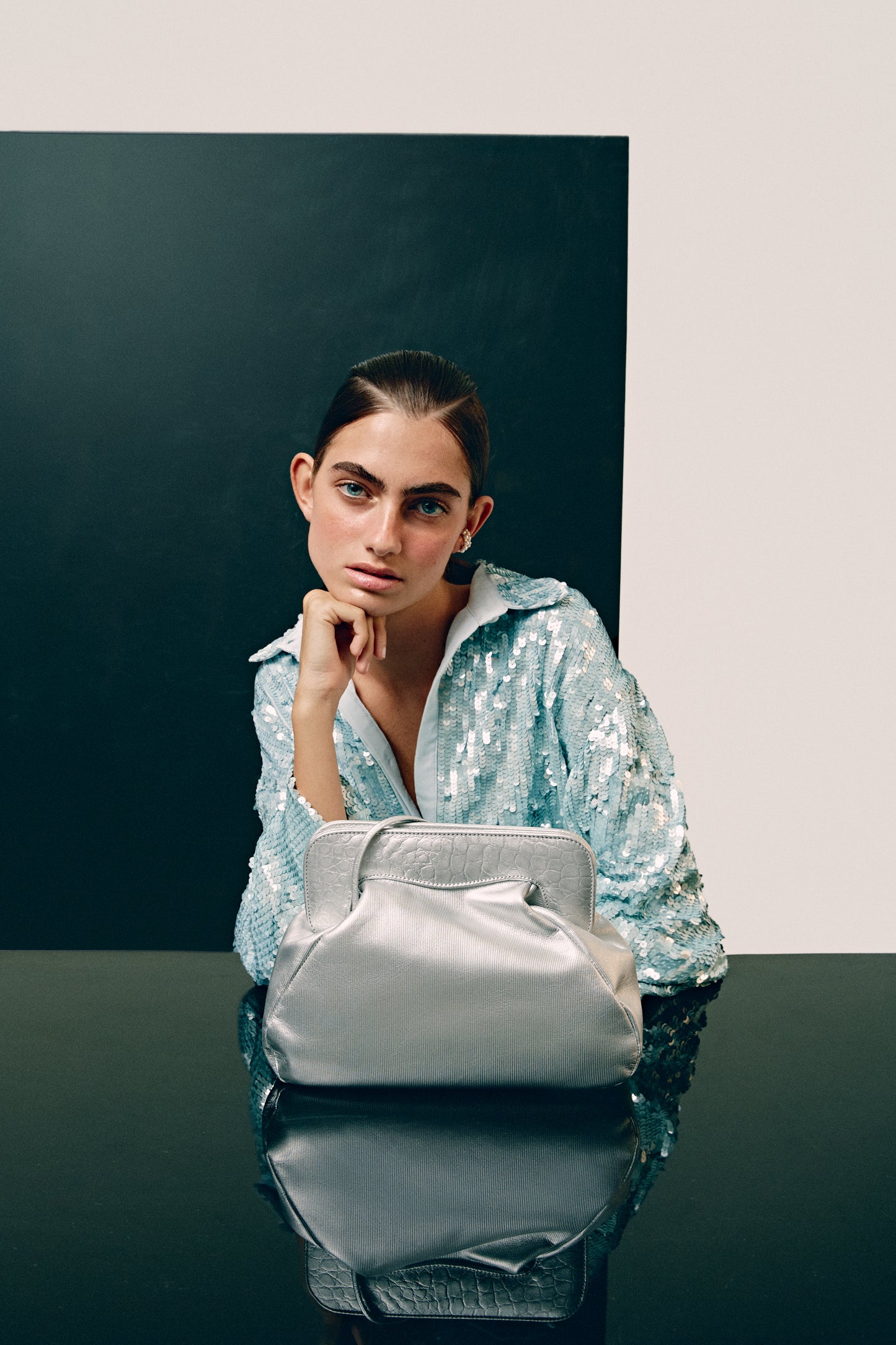 Chica con un bolso de mano plateado con piel efecto cocodrilo