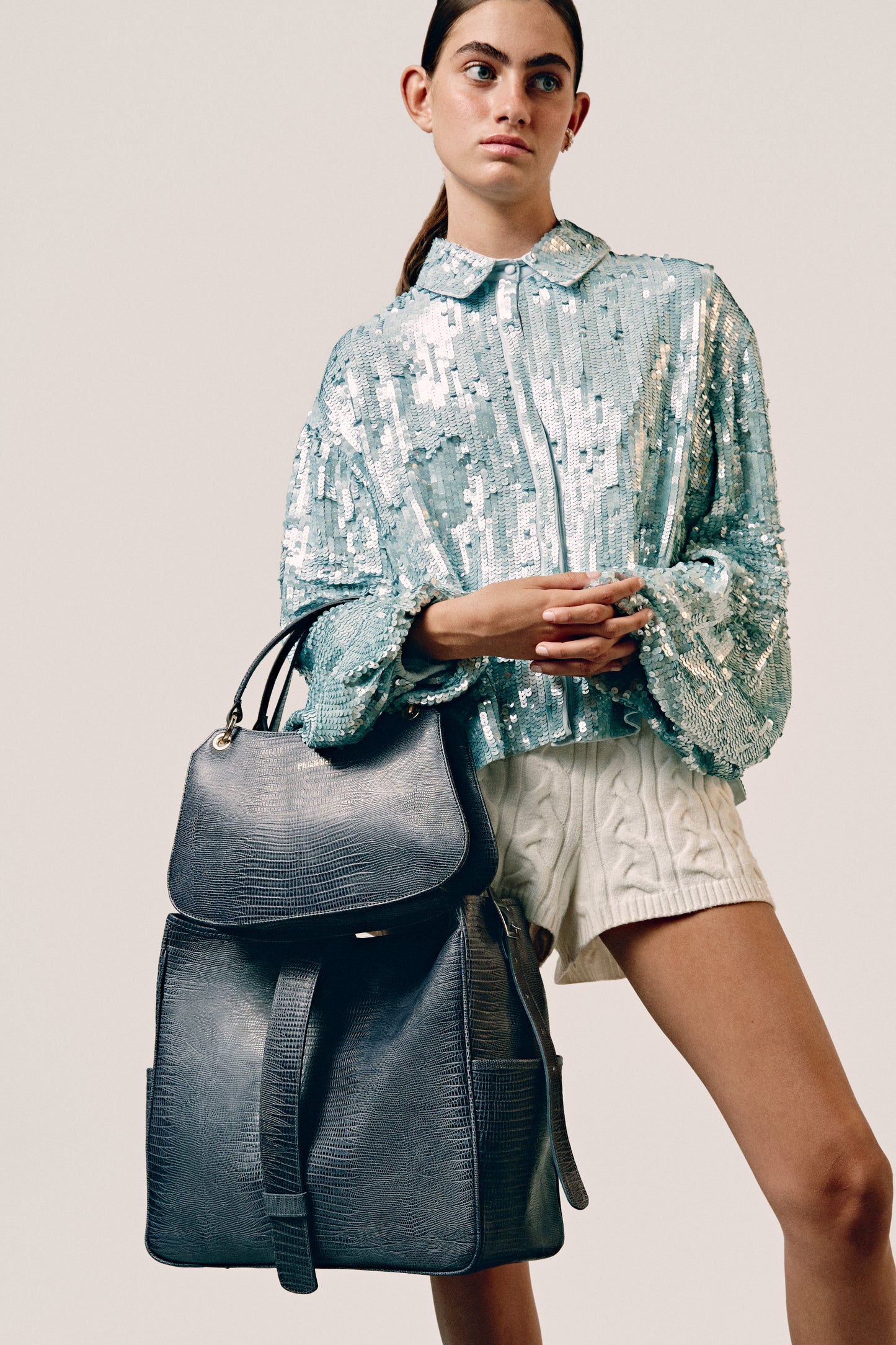 Chica con top de lentejuelas con un bolso de mano y otro shopper gris lizard