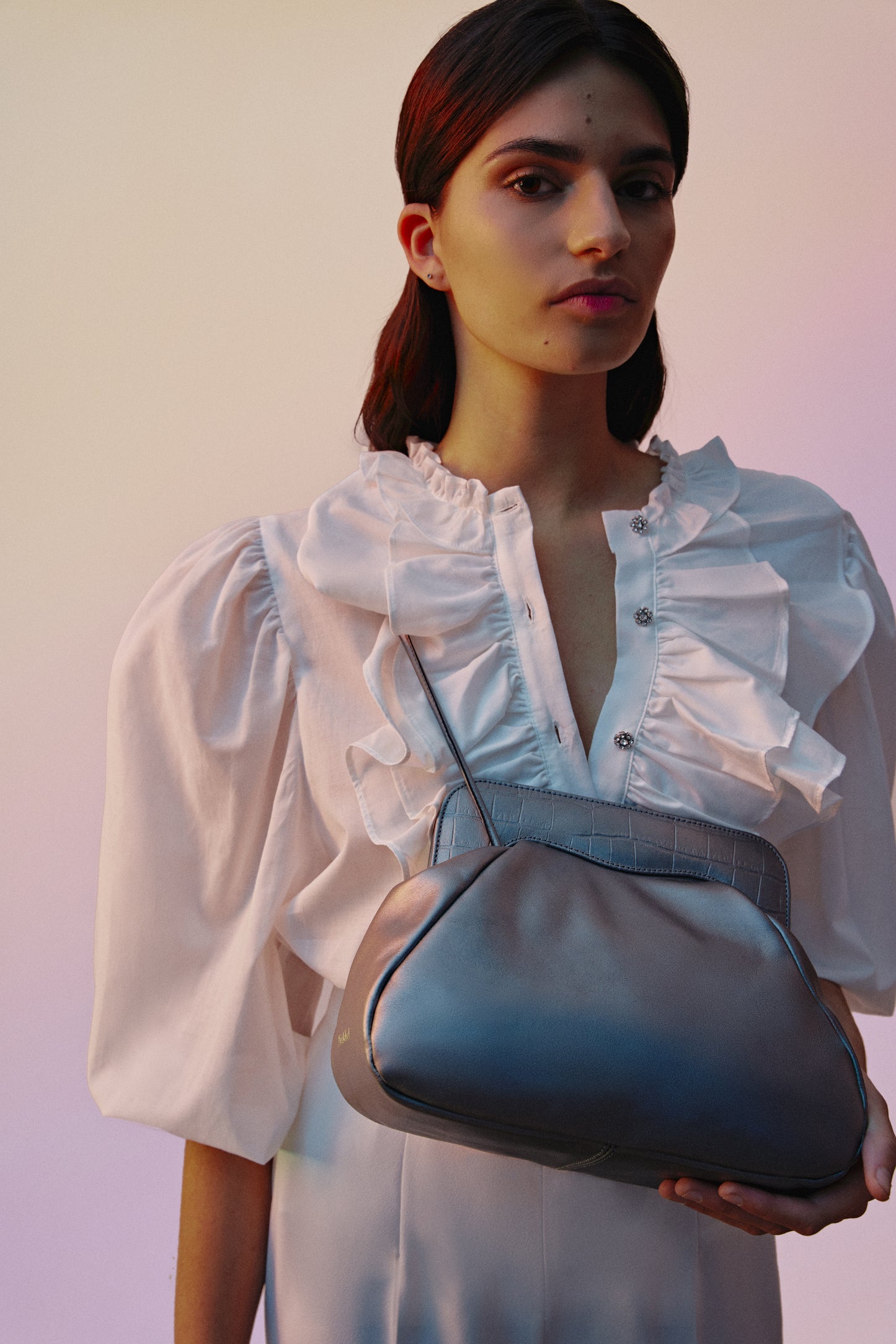 Mujer con bolso de hombro en color plata vieja metalizada