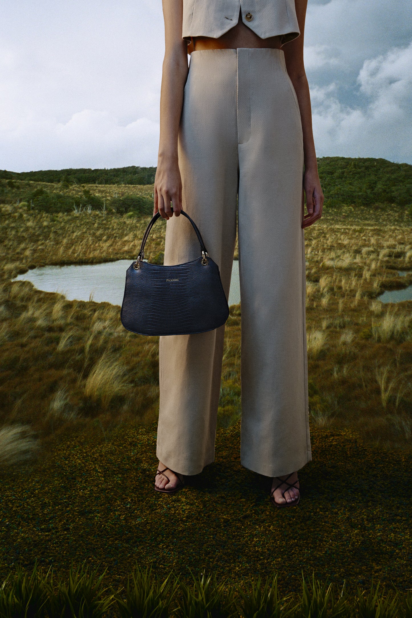 Mujer sosteniendo un bolso gris lizard metalizado