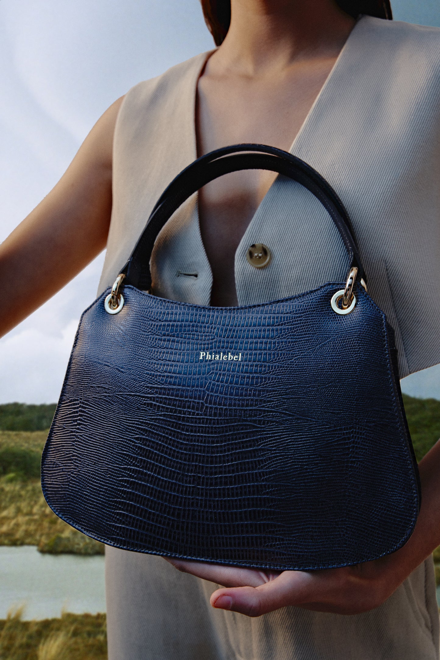 Bolso de mano gris metalizado efecto lizard con detalles dorados