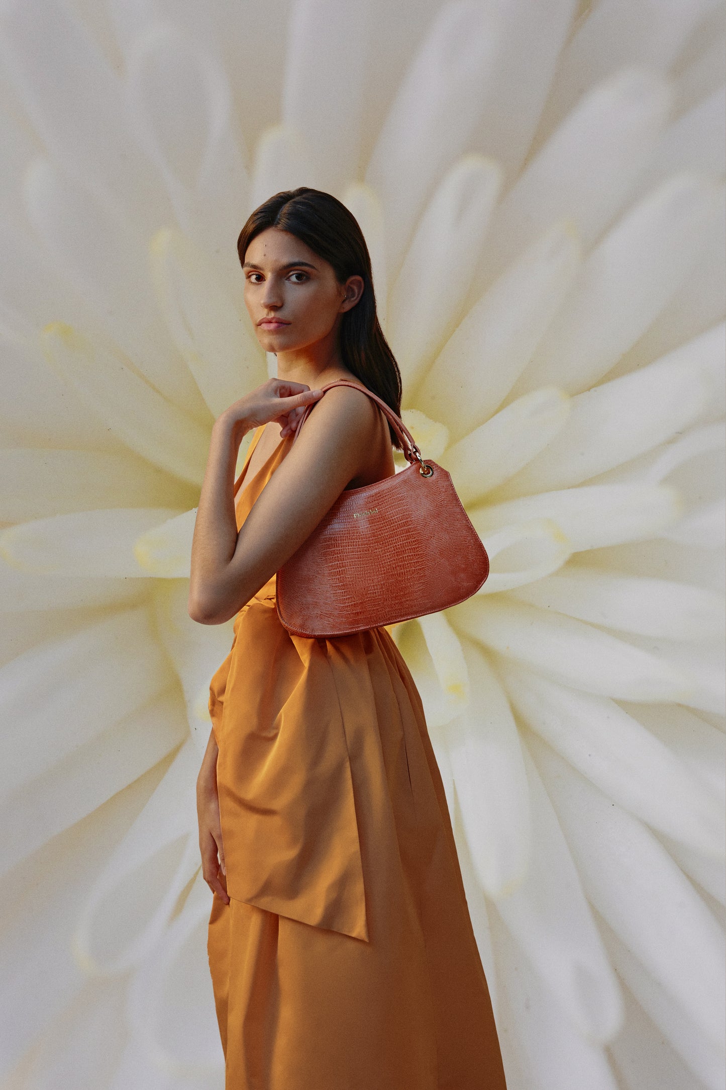 Mujer combinando un bolso naranja metalizado lizard con un vestido del mismo color