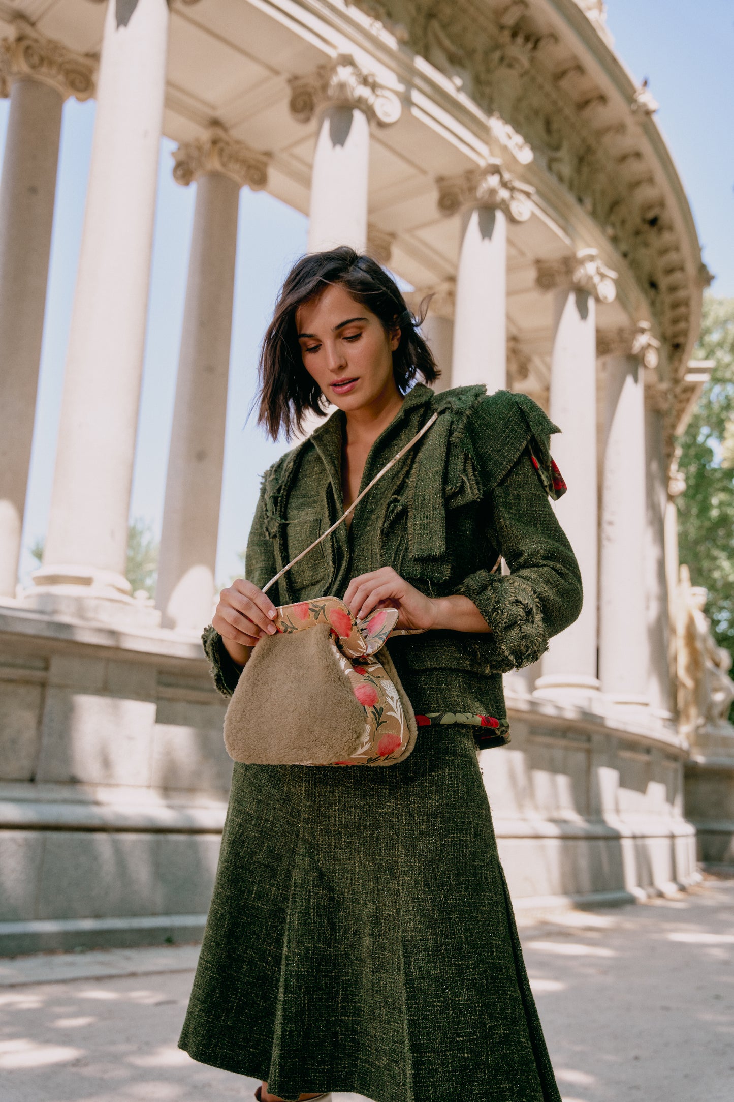 Mujer con abrigo verde con un bolso borreguito marrón