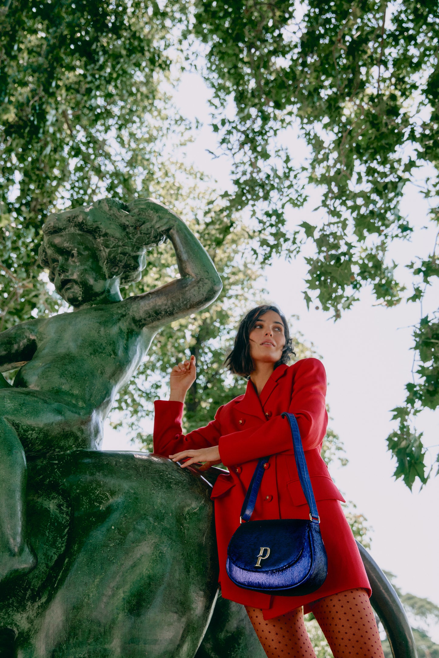 Chica posando con un bolso de correa de lentejuelas azules