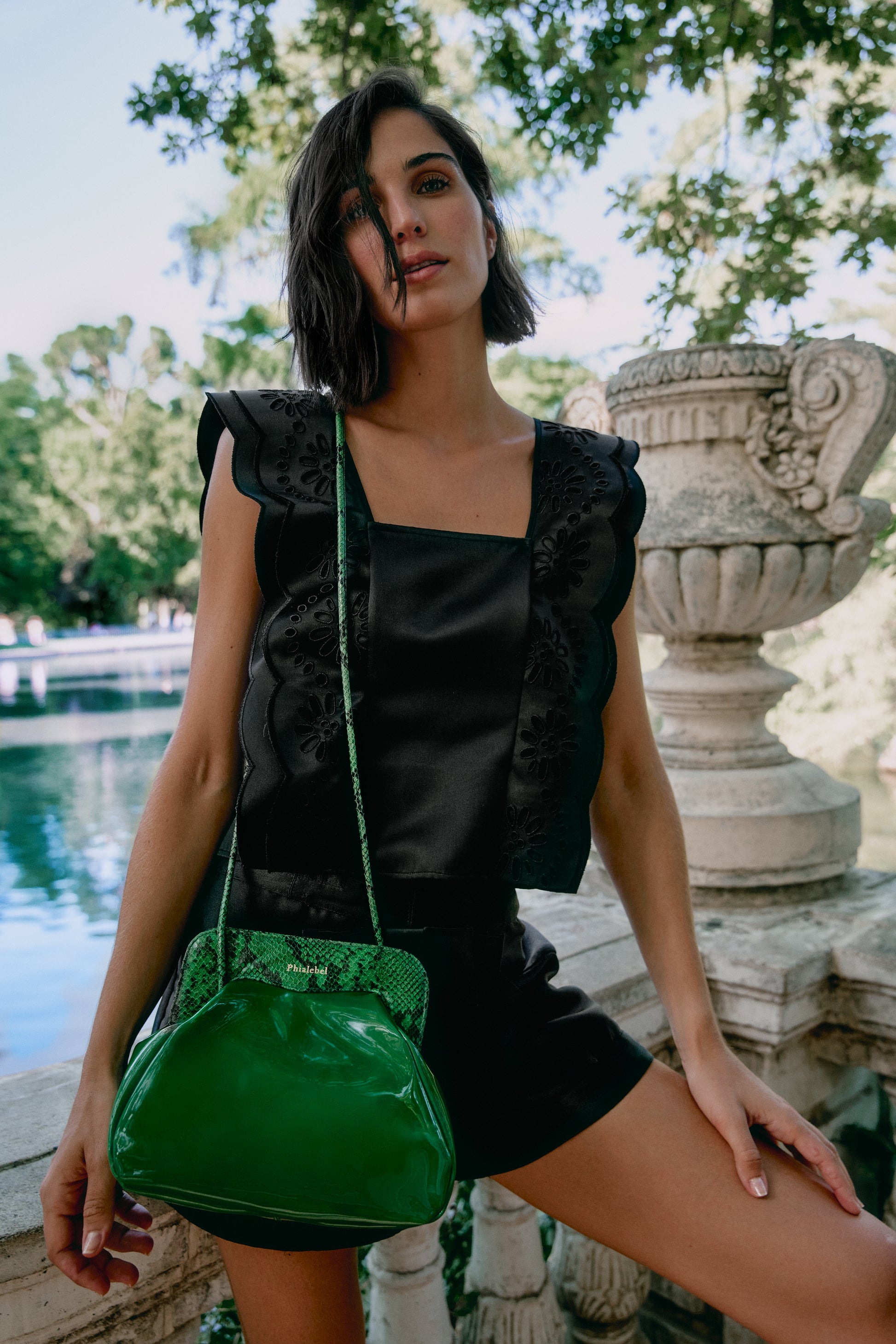 Chica con ropa de verano con un bolso de hombro verde con detalles de piel de serpiente