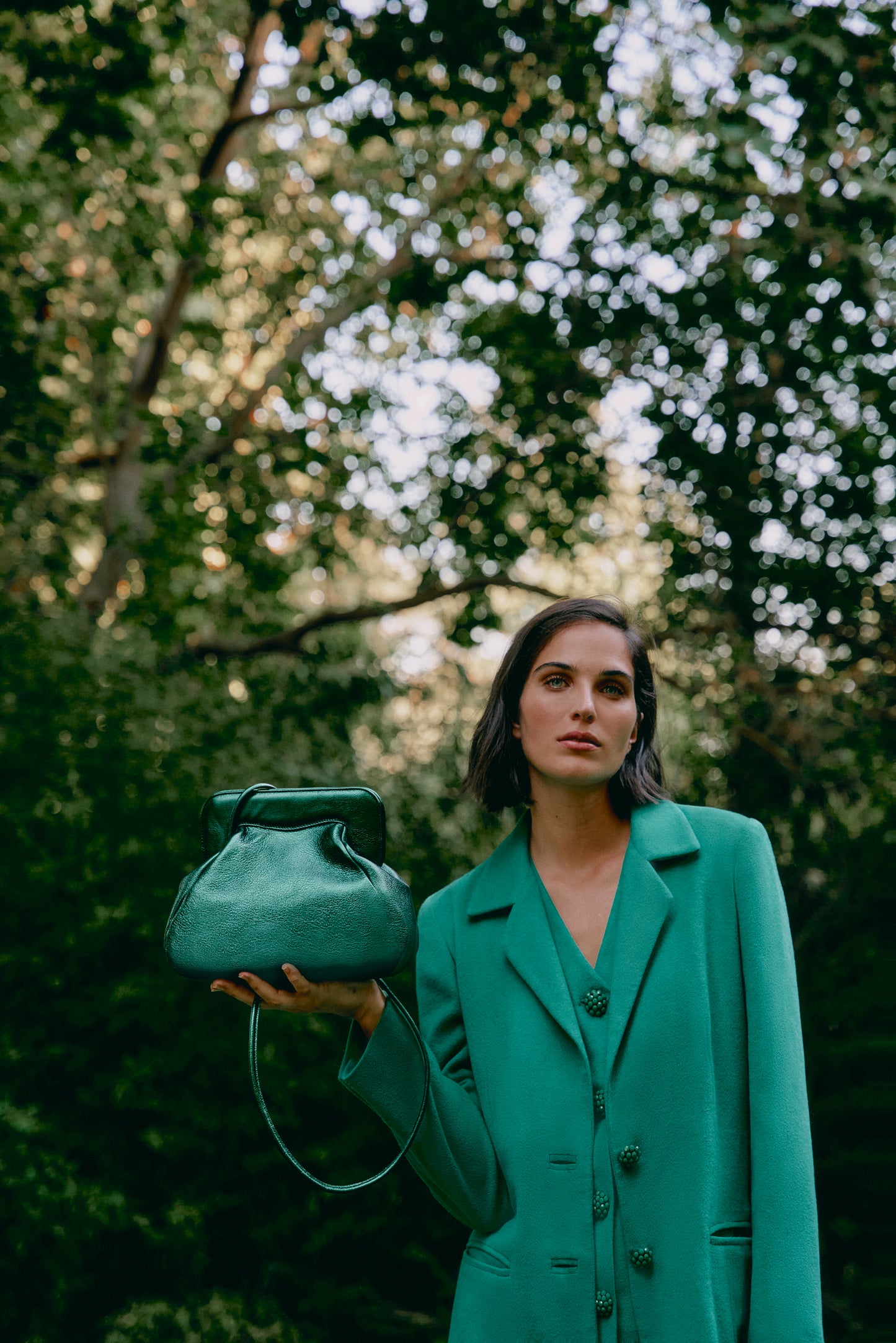 Mujer sosteniendo un bolso verde metalizado