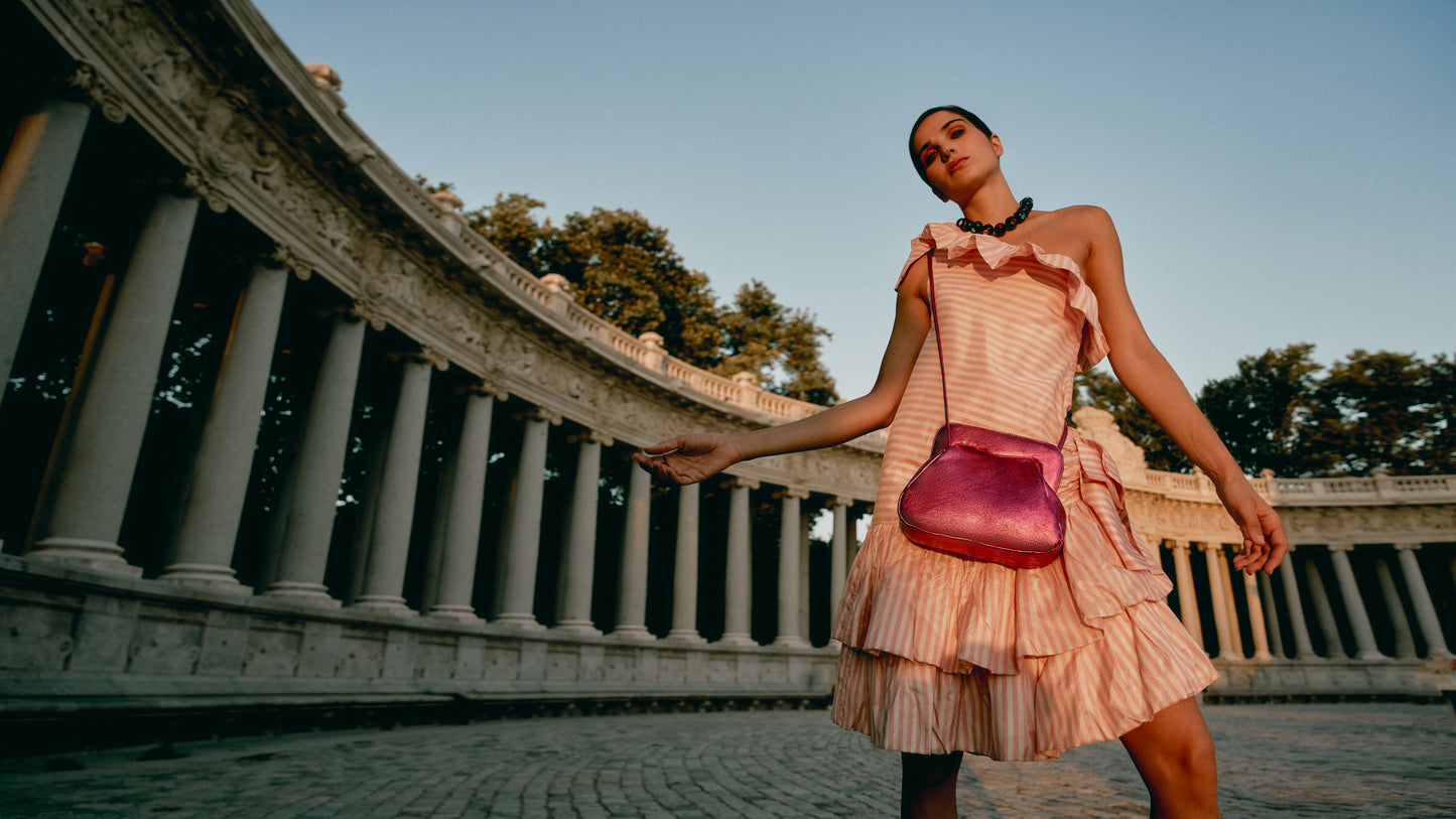 Chica posando con bolso rosa metalizado