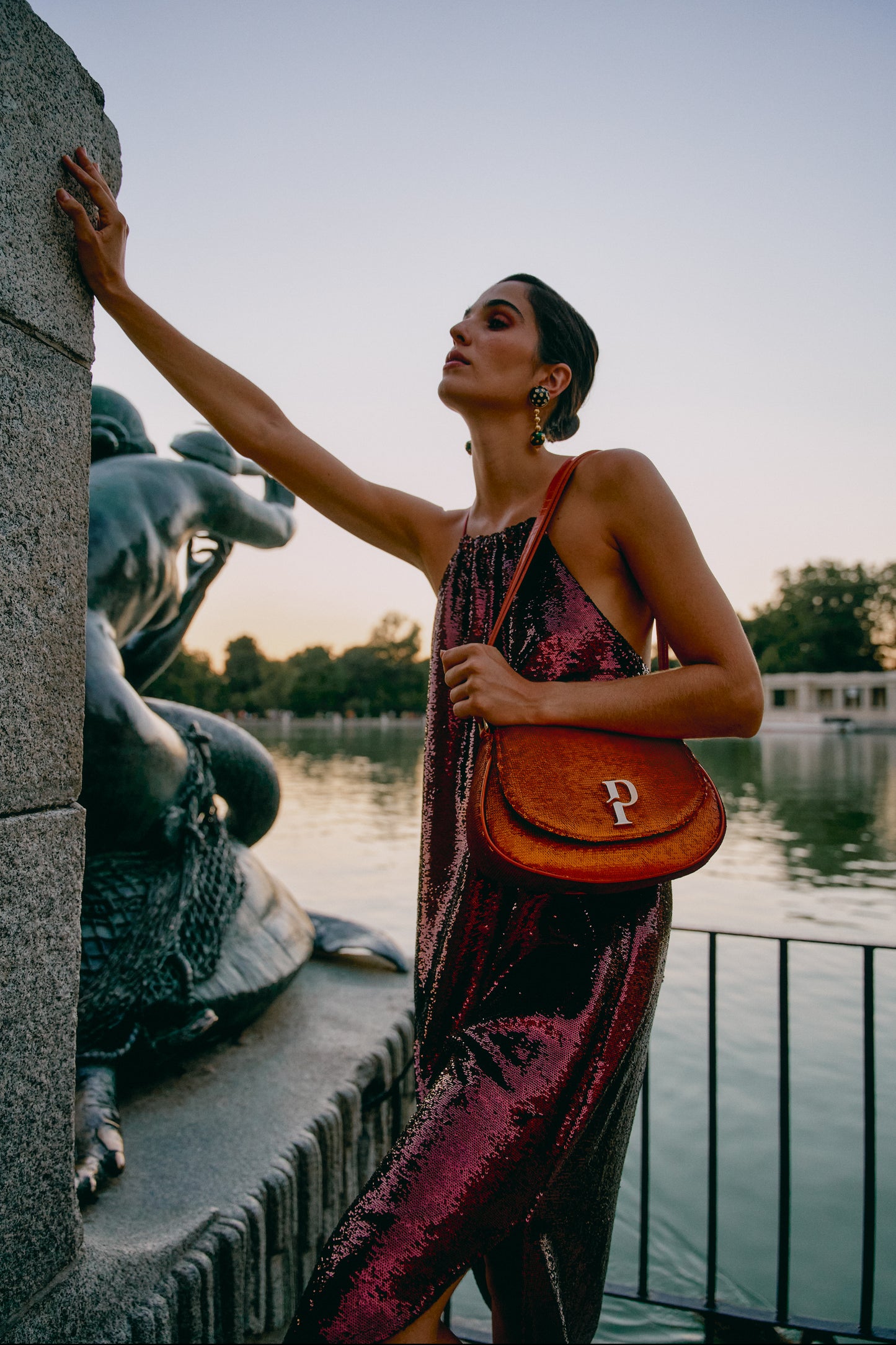 Mujer posando con un hombro naranja de lentejuelas al hombro