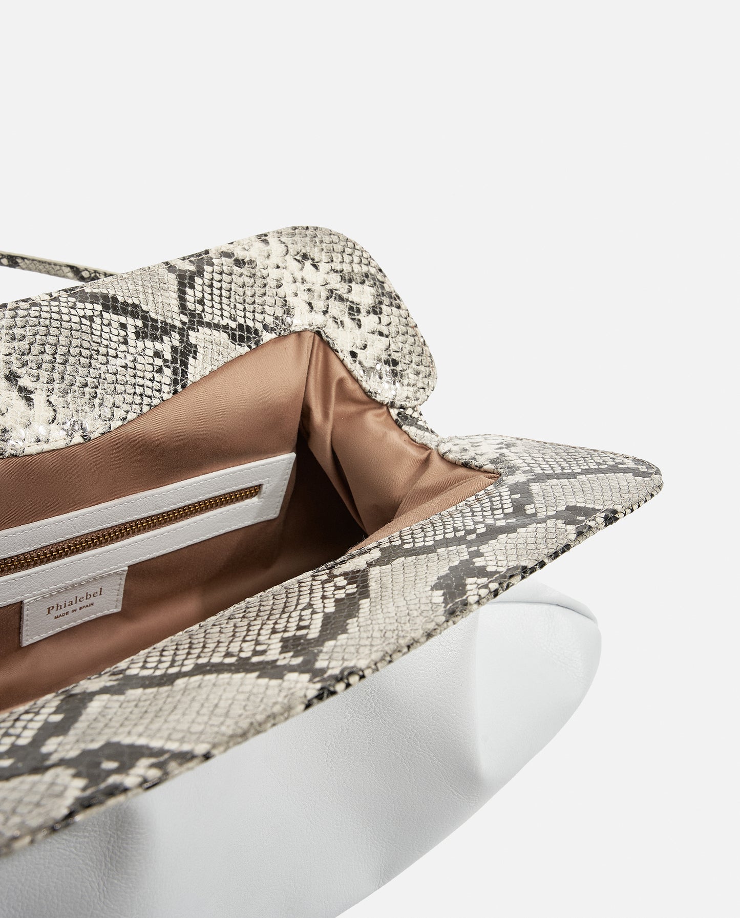 Detalle de la solapa serpiente y el interior de un bolso shopper blanco