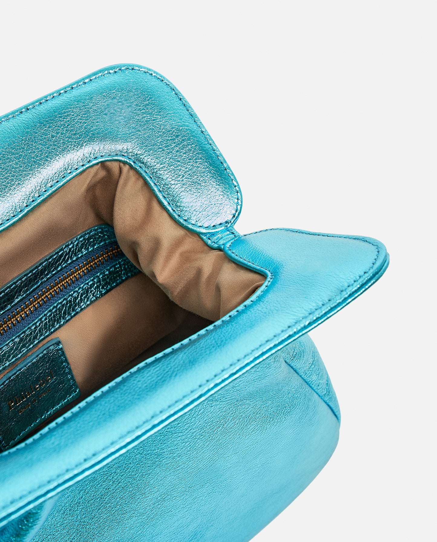 Detalle del interior de bolso azul en acabado metalizado