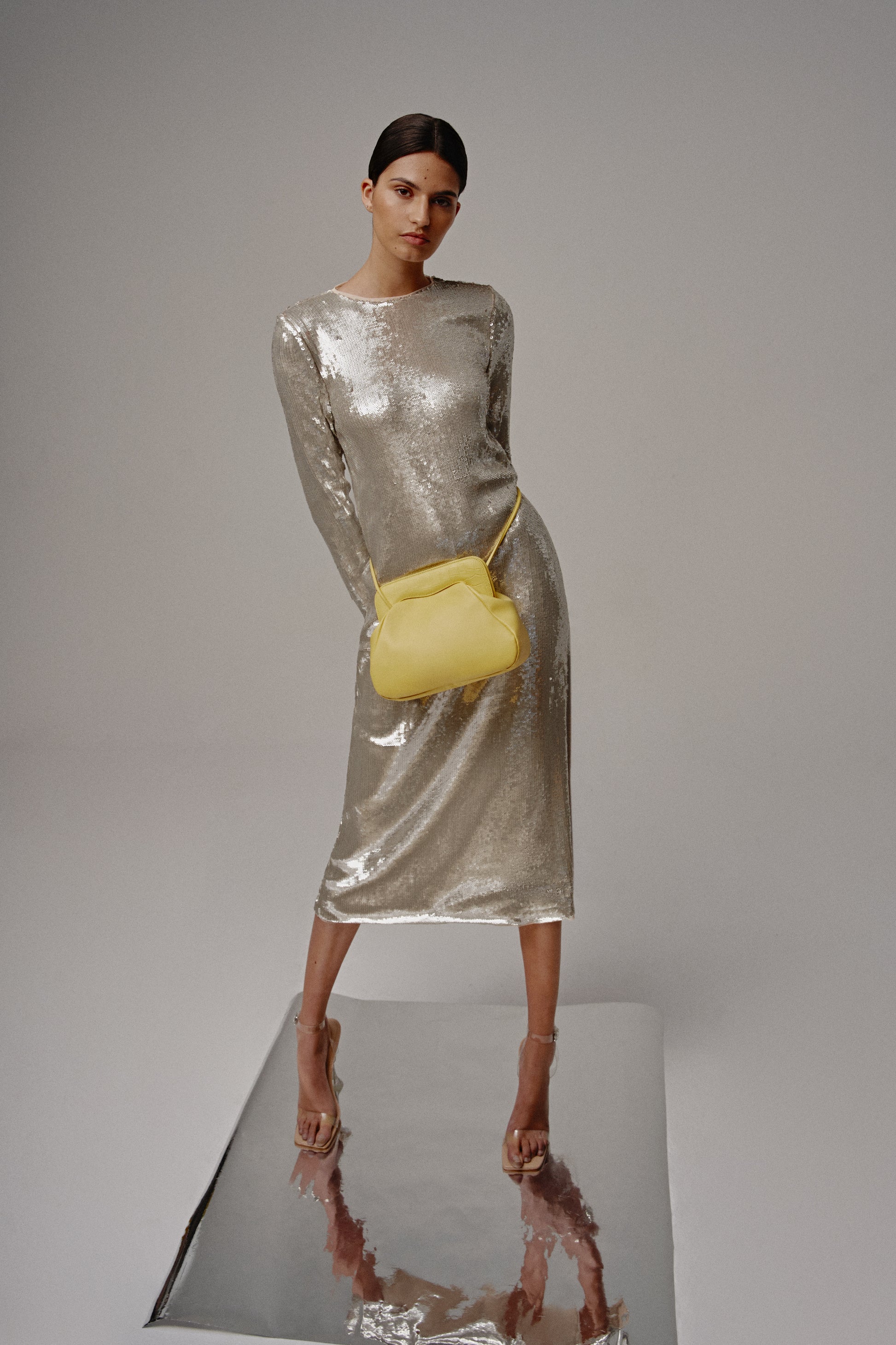 Modelo de gris posando con un bolso amarillo