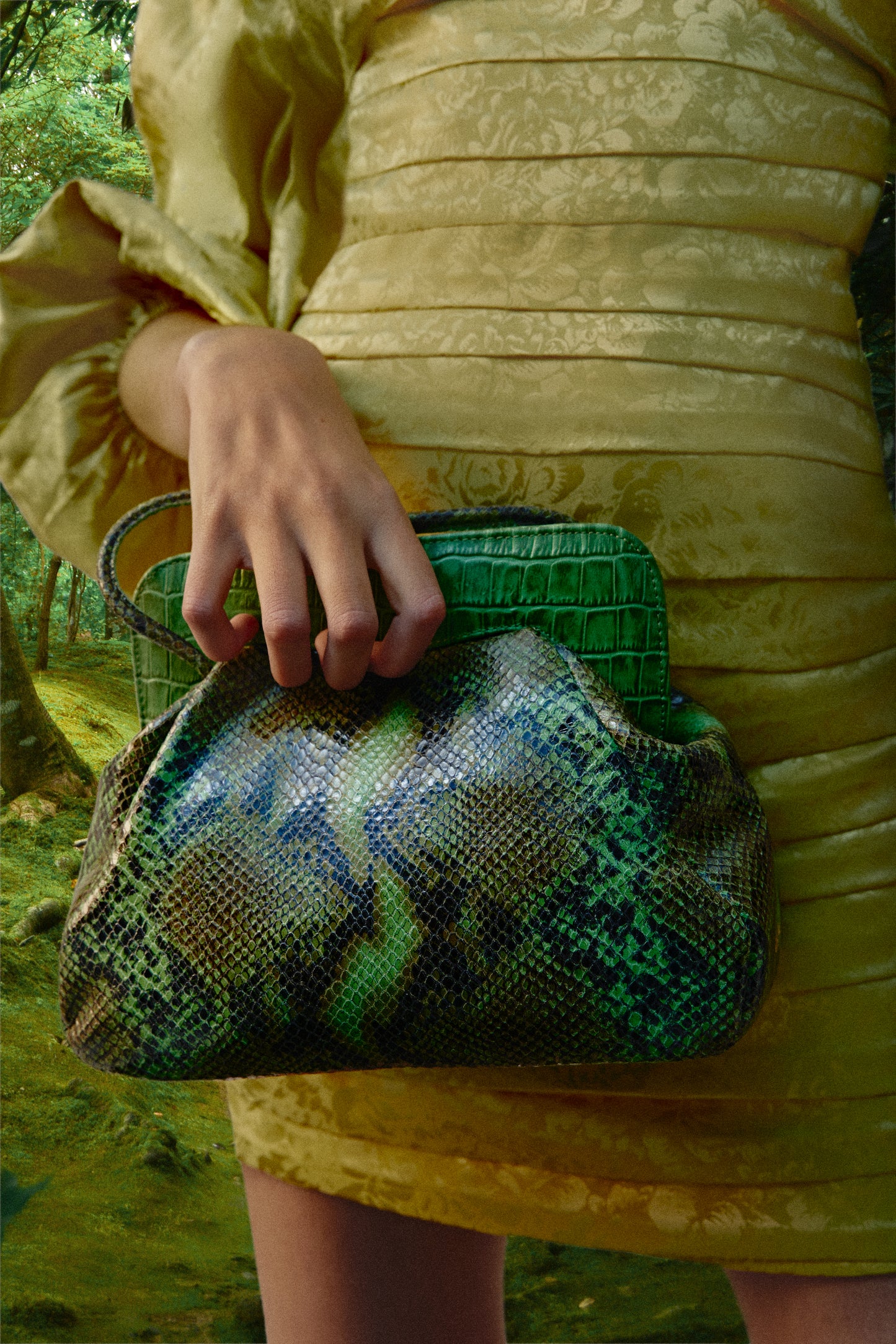 Primer plano de un bolso verde con estampado efecto piel de serpiente