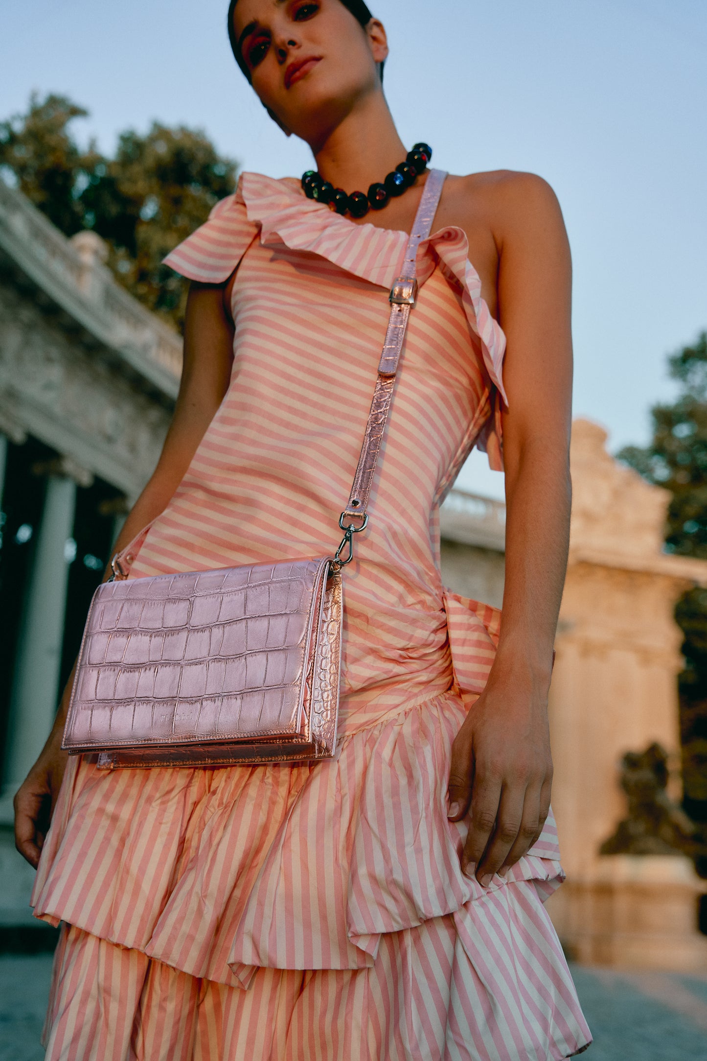 Chica con vestido y bolso rosa metalizado de fiesta