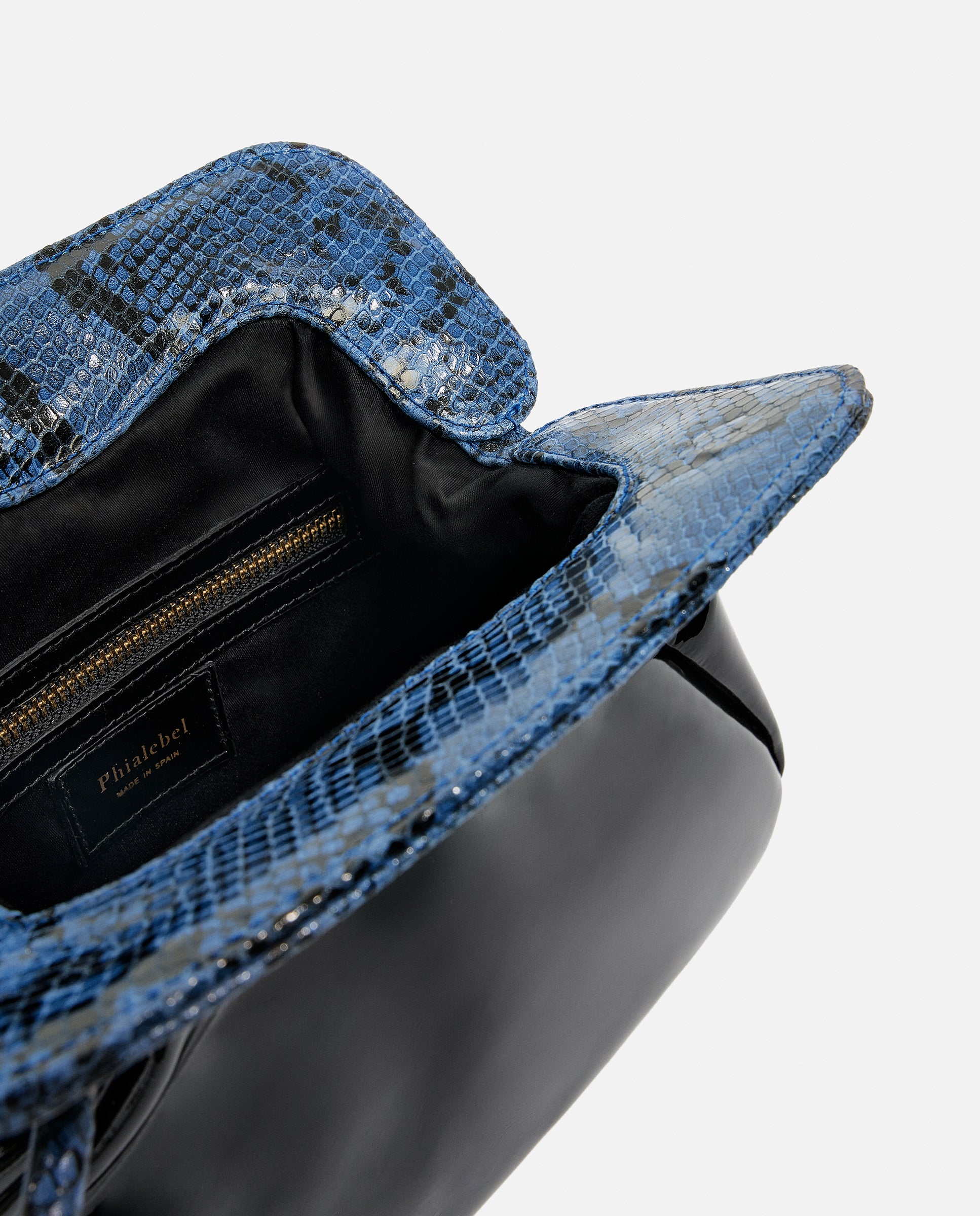Detalle de bolso negro y azul hecho artesanalmente en charol