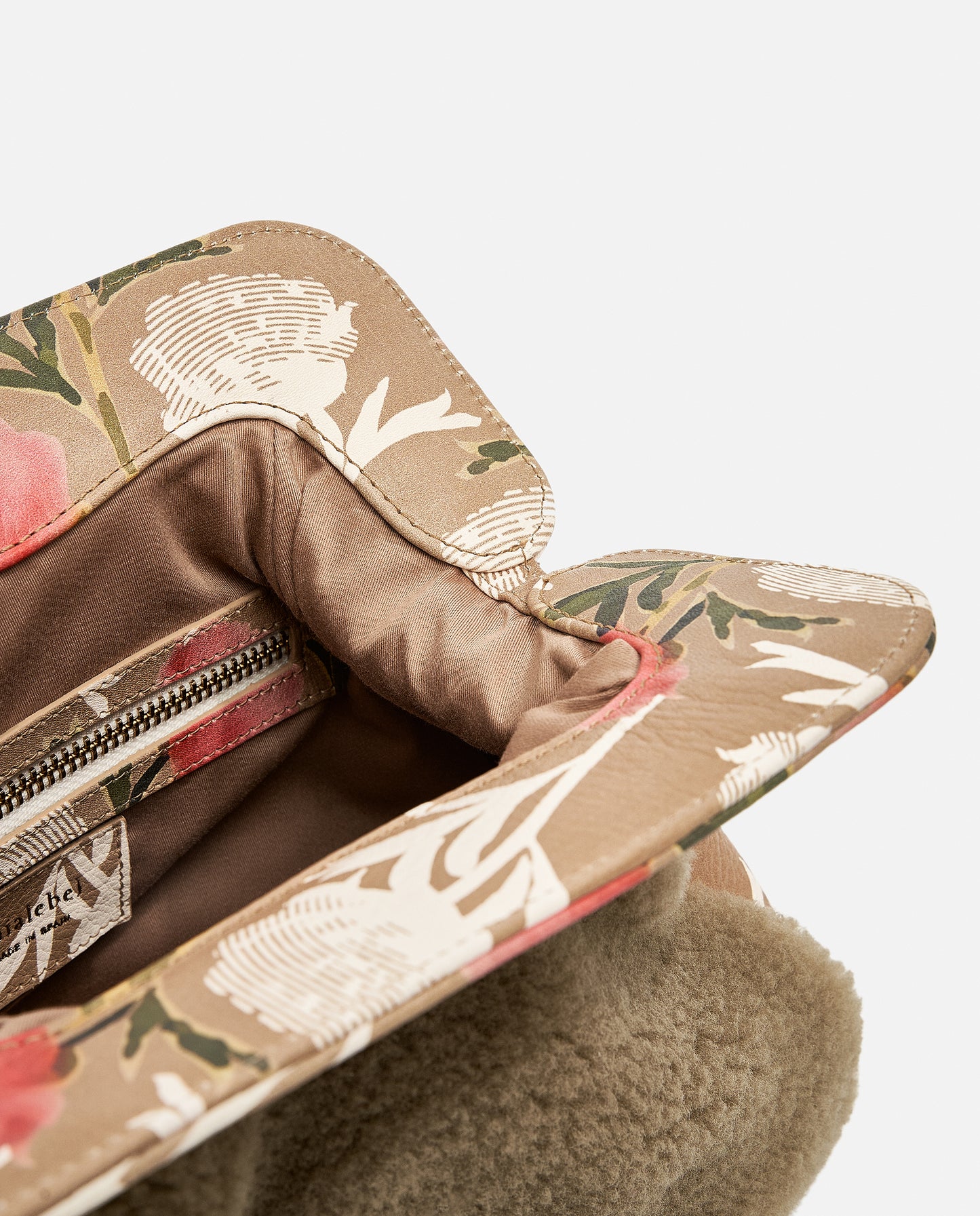 Detalles florales en la solapa de un bolso borreguito marrón